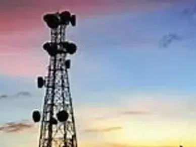 A cell phone tower with many antennas on top of it.