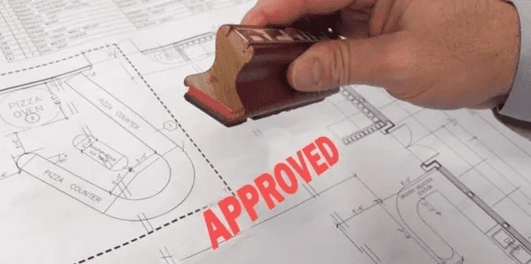 A rubber stamp is being used to seal an approved document.